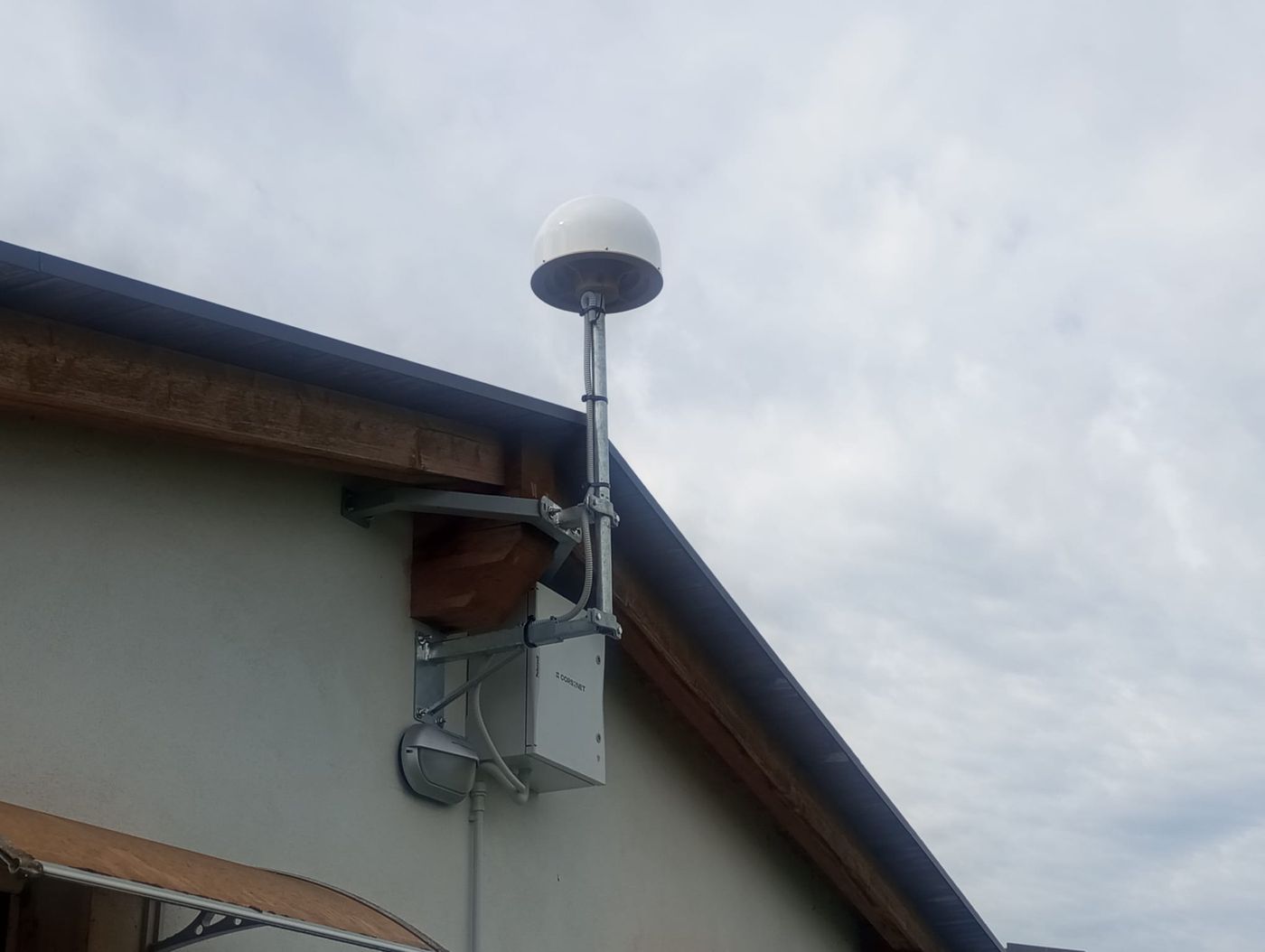 StarCORS reference antenna and enclosure mounted at the edge of a roof
